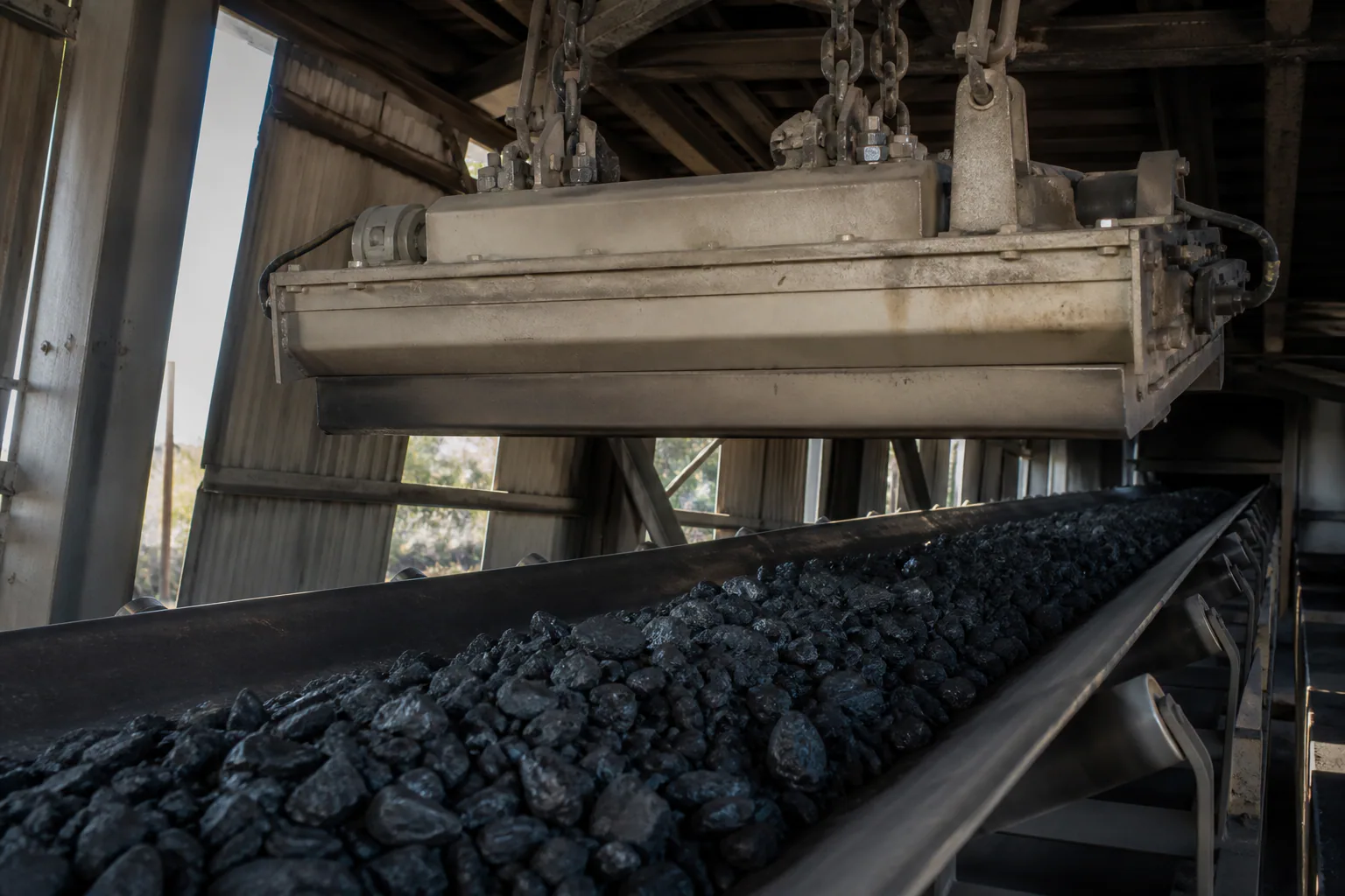 Suspended magnetic separator above a coal conveyor